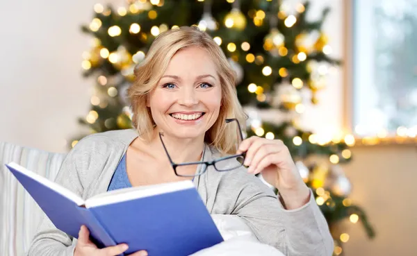 Smiling woman reading book at home on christmas Stock Photo