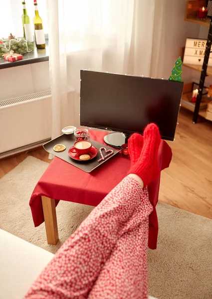 Ноги в красных носках на столе дома на Рождество — стоковое фото