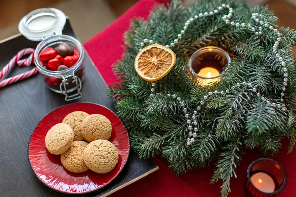 Plätzchen, Bonbons und Adventskranz mit Kerze — Stockfoto