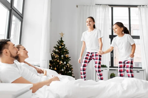 Glückliche Kinder wecken ihre Eltern an Weihnachten lizenzfreie Stockfotos