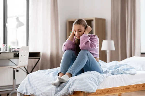 Chica triste sentada en la cama en casa — Foto de Stock