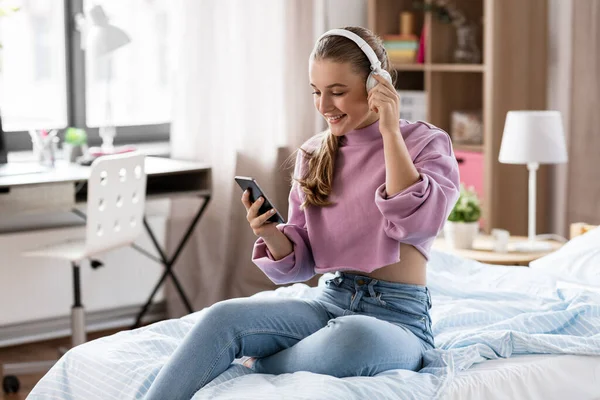 Chica en auriculares con smartphone en casa — Foto de Stock