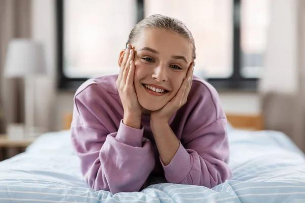 행복 한 미소짓는 소녀 가 집에서 침대에 누워 — 스톡 사진