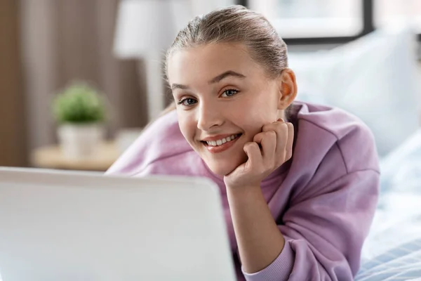 Chica sonriente con ordenador portátil en casa —  Fotos de Stock