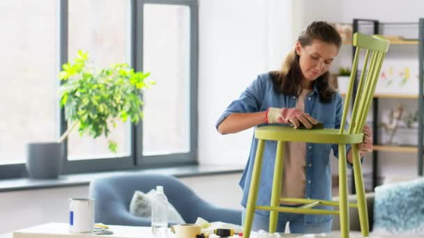 Femme ponçage vieille chaise ronde en bois avec éponge — Video