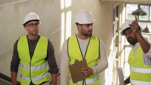 Arquitetos em capacetes andando lá em cima no escritório — Vídeo de Stock