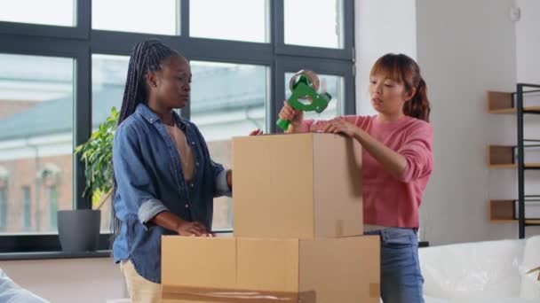 Ženy s lepicí páskou balení krabice doma — Stock video