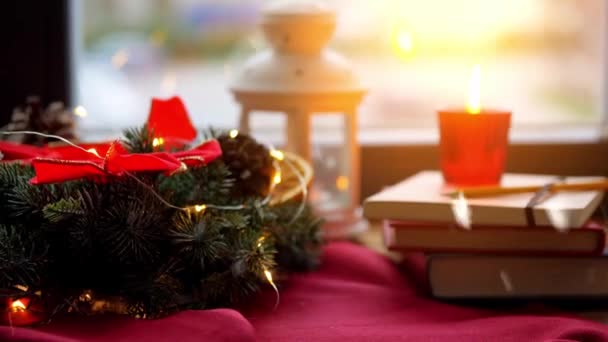 Świąteczny wieniec, książki, świeca, latarnia na oknie — Wideo stockowe