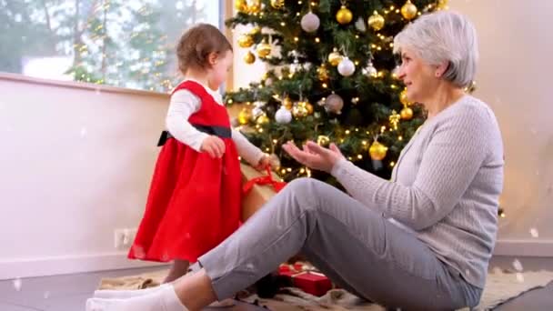 Oma en baby meisje met kerstcadeaus — Stockvideo