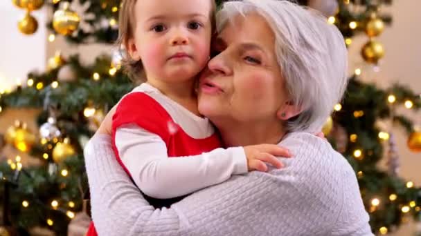 Grootmoeder en baby meisje knuffelen op kerst — Stockvideo