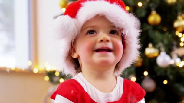 Счастливая девочка в шляпе Санта-Клауса у себя дома — стоковое видео
