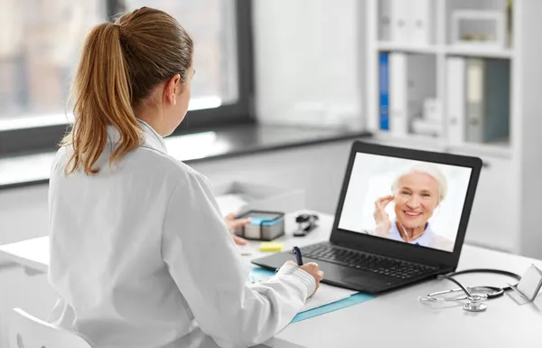 Doctor with laptop having video call with patient — Stock Photo, Image