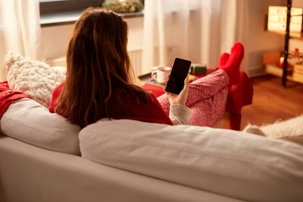 Mujer usando el teléfono inteligente en casa en Navidad —  Fotos de Stock