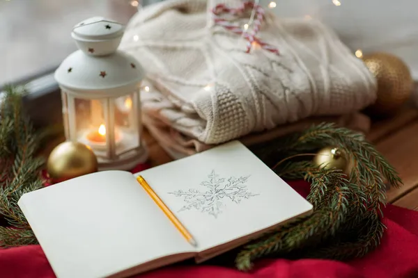 Vázlatfüzet, karácsonyi lámpa, pulóver, fenyő ág — Stock Fotó
