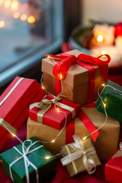 Presentes de Natal na toalha de mesa vermelha na soleira da janela — Fotografia de Stock