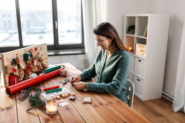 Kvinna gör adventskalender på jul hemma — Stockfoto