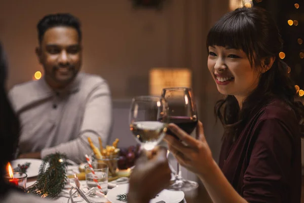 Amigos felices bebiendo vino en la fiesta de Navidad —  Fotos de Stock