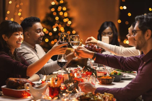 Happy friends drinking wine at christmas party — Stock Photo, Image