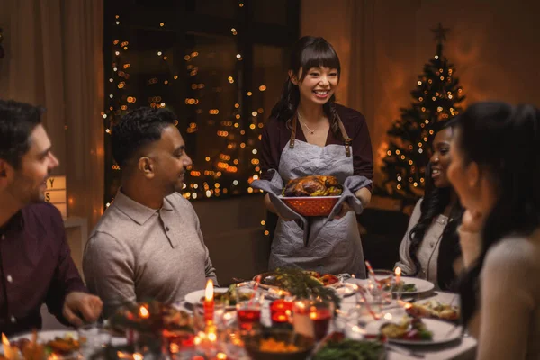 Amigos felices teniendo la cena de Navidad en casa — Foto de Stock