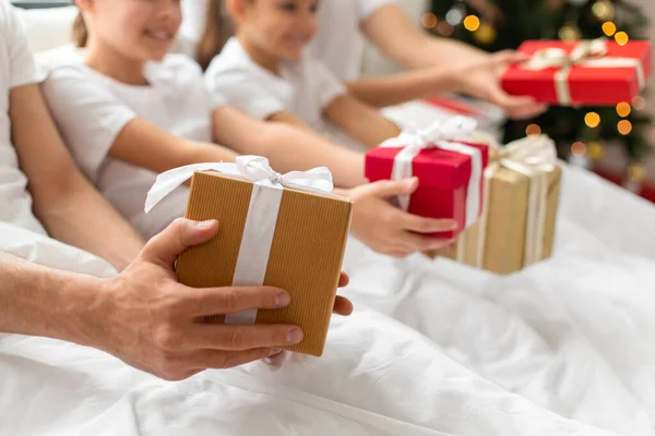 Familia con regalos de Navidad en la cama en casa — Foto de Stock