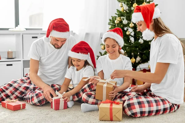 Feliz familia abriendo regalos de Navidad en casa — Foto de Stock