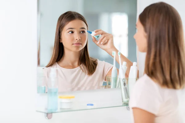 Adolescente con gotas para los ojos delante del espejo — Foto de Stock