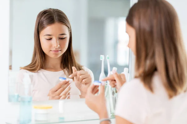 Ragazza adolescente che applica lenti a contatto in bagno — Foto Stock