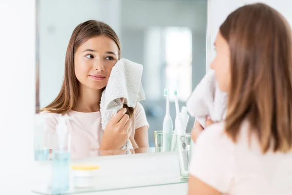 Chica adolescente limpiando la cara con toalla en el baño — Foto de Stock