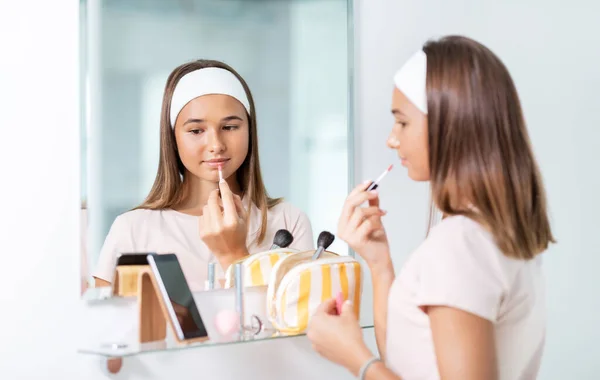 Adolescent fille application lèvre brillant à salle de bain — Photo