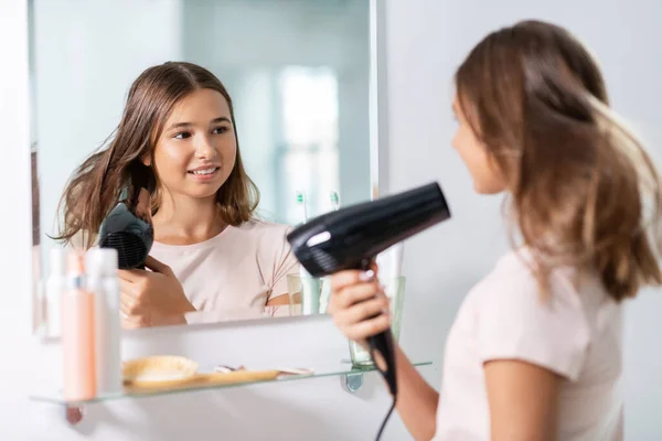 Adolescente com secador de cabelo no banheiro — Fotografia de Stock