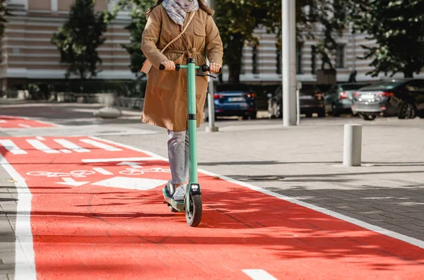 Mujer montando scooter a lo largo de carril bici carretera en la ciudad —  Fotos de Stock