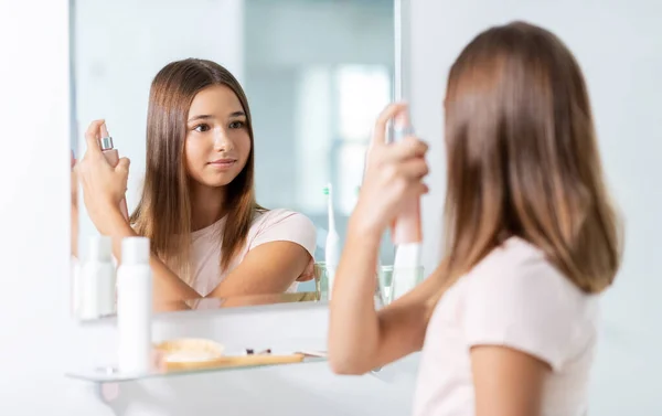 Девушка-подросток с помощью лака для волос в ванной комнате Лицензионные Стоковые Фото