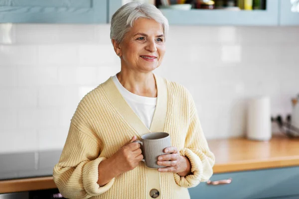 Femme heureuse avec tasse de café sur la cuisine à la maison — Photo