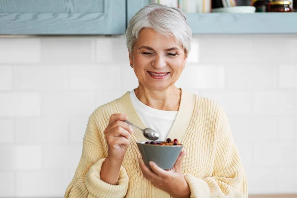 Donna con cereali per la prima colazione in cucina a casa — Foto Stock