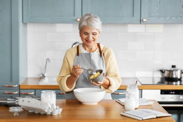 Lycklig kvinna matlagning mat på köket hemma — Stockfoto