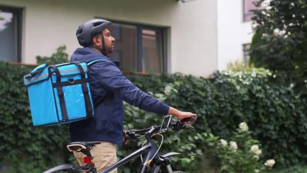 Şehirde çanta ve bisikletli Hintli teslimatçı. — Stok video