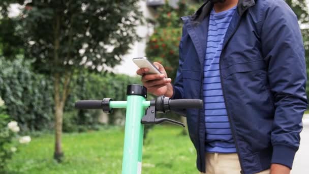 Hombre con smartphone montar scooter eléctrico — Vídeo de stock