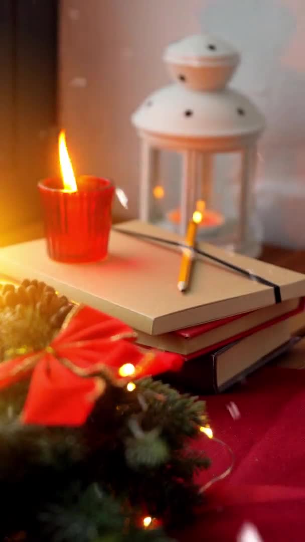 Χριστουγεννιάτικο στεφάνι, βιβλία, κεριά, φανάρι στο παράθυρο — Αρχείο Βίντεο