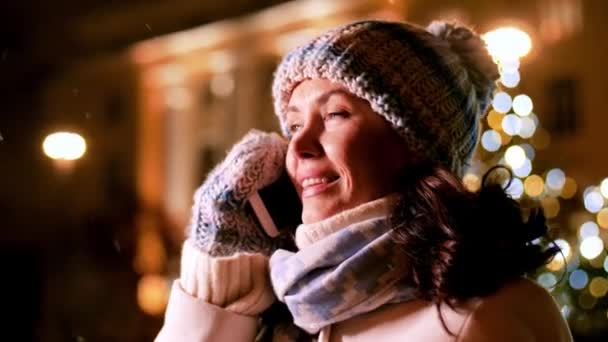 Glad kvinna ringer på smartphone på jul — Stockvideo