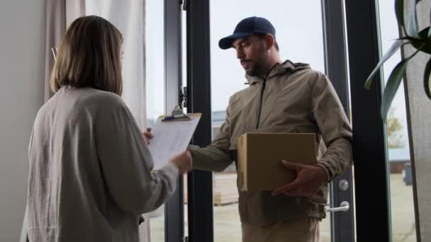 Delivery man with parcel box and customer at home — Stock Video