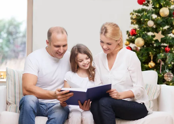 Glückliche Familie liest Buch zu Hause an Weihnachten — Stockfoto