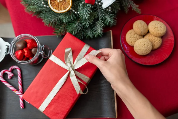 Hand mit Weihnachtsgeschenk, Leckereien und Dekorationen — Stockfoto