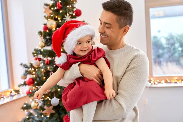 Gelukkig vader en baby meisje over kerstboom — Stockfoto