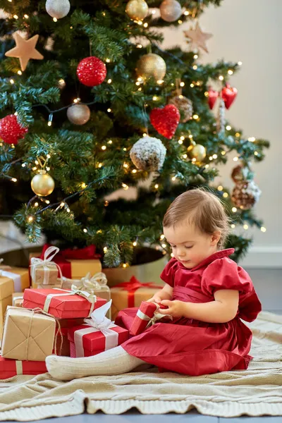 Glücklich Baby Mädchen öffnet Weihnachtsgeschenke zu Hause — Stockfoto