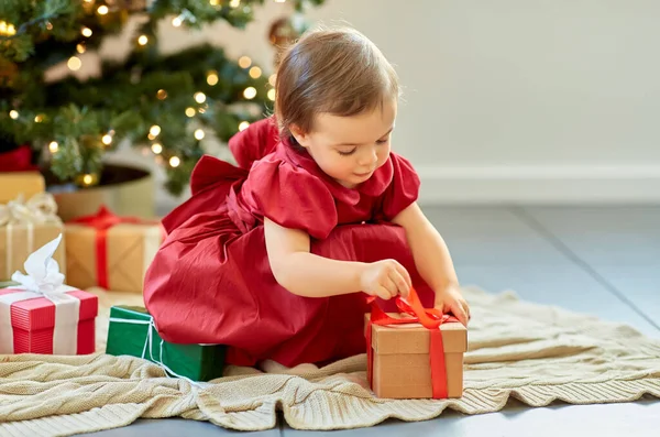 Gelukkig baby meisje opening kerstcadeaus thuis — Stockfoto