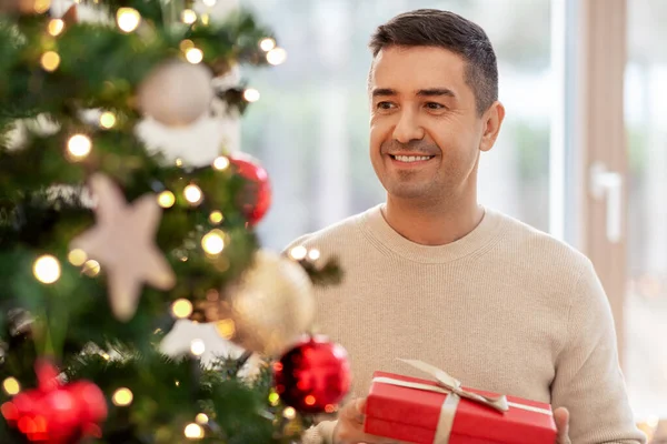 Happy middle aged man with christmas gift at home — Stock Photo, Image