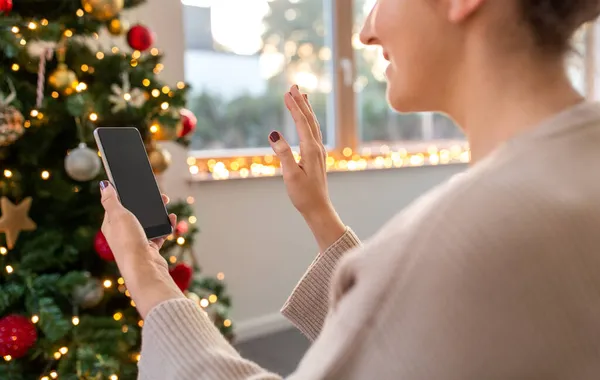 Mujer con smartphone tiene videollamada en Navidad —  Fotos de Stock