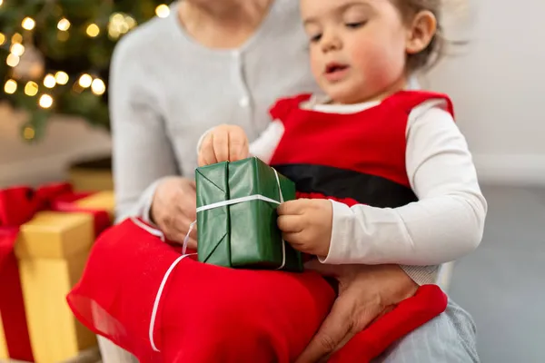 Großmutter und kleines Mädchen mit Weihnachtsgeschenk — Stockfoto