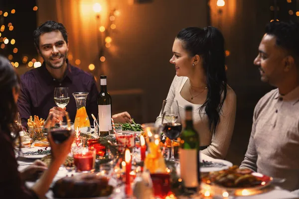 Amigos felizes bebendo vinho na festa de Natal — Fotografia de Stock