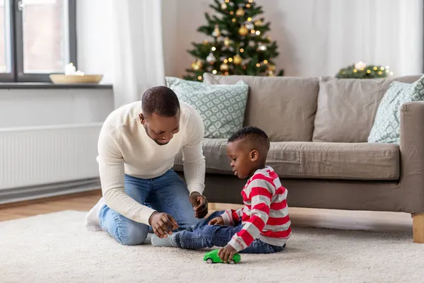 幸せな父親は家でクリスマスに息子と遊ぶ — ストック写真